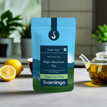 Svamingo nilgiri green tea pouch 100g on a marble table in kitchen with lemons, tea cups, green tea pot on the side